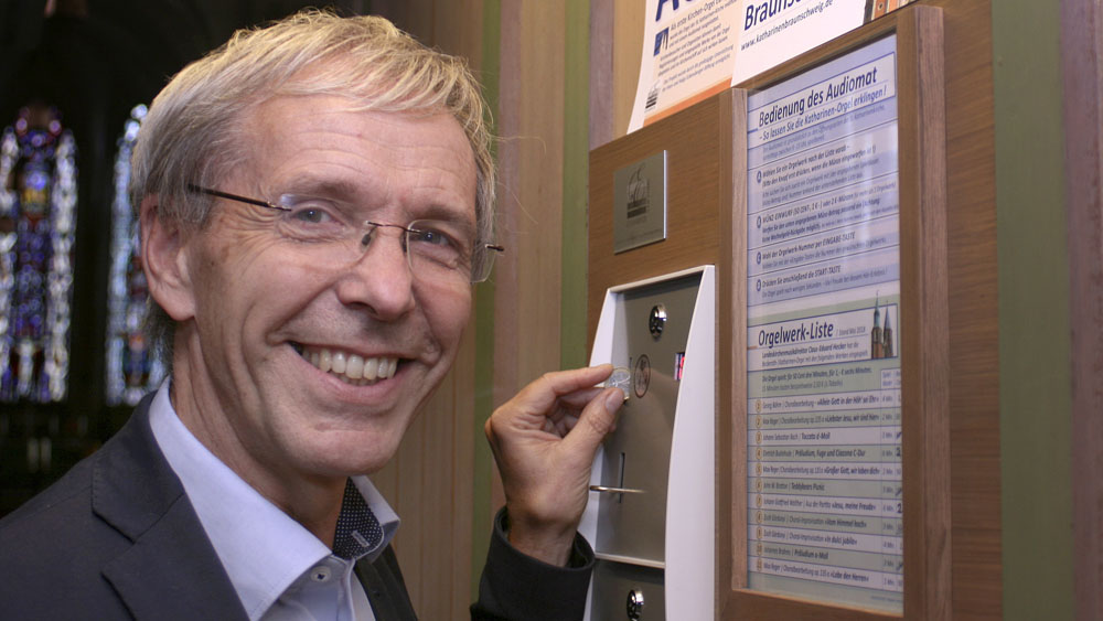 Landeskirchenmusikdirektor Claus-Eduard Hecker wirft eine Münze ein