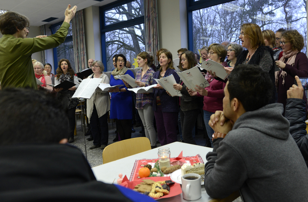 Der Chor "Vocalvielharmonie" singt, und die Flüchtlinge im Flüchtlingshaus Osnabrück hören zu
