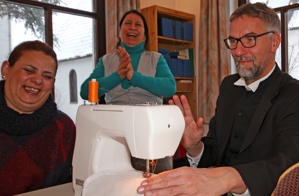 Bischof Jan Janssen versucht sich an der Nähmaschine