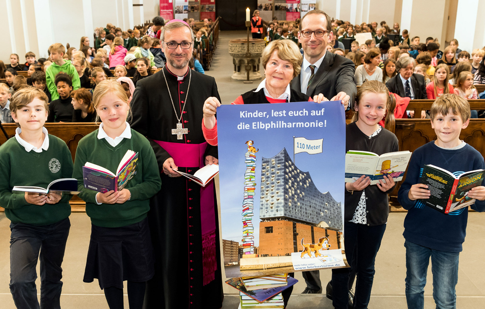 Erzbischof Stefan Heße, Kinderbuchautorin Ursel Scheffler und Elbphilharmonie-Intendant Christoph Lieben-Seutter mit lesebegeisterten Kindern