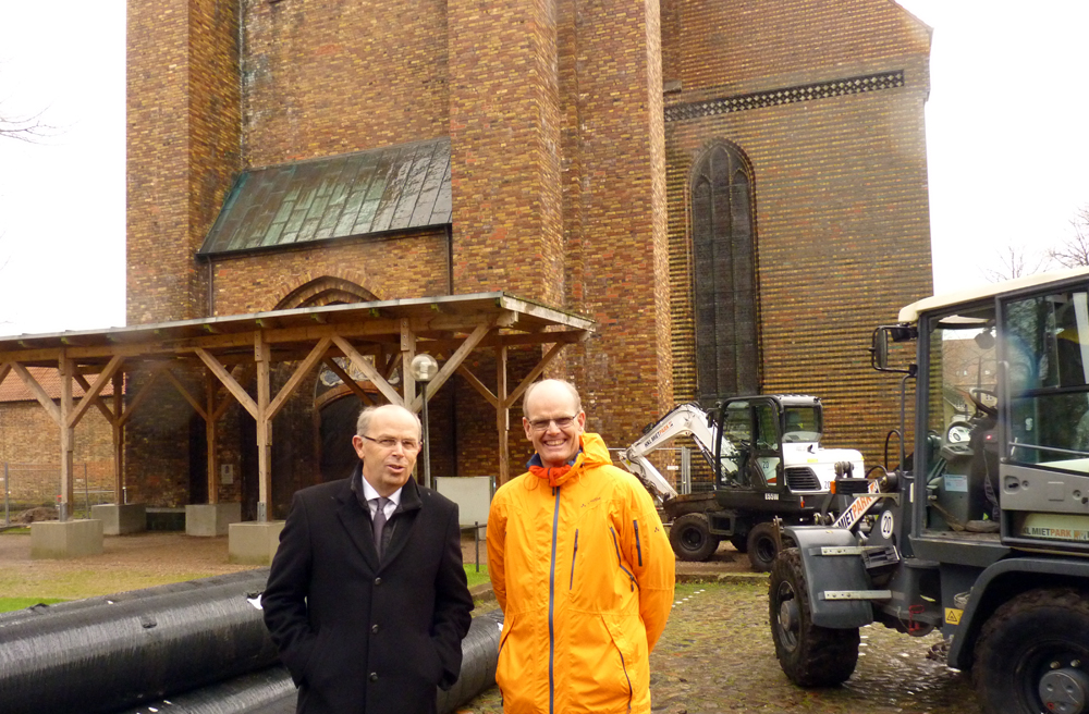 Bischof Gothart Magaard und Projektkoordinator Andreas Hamann vor dem geschlossenen Turmportal