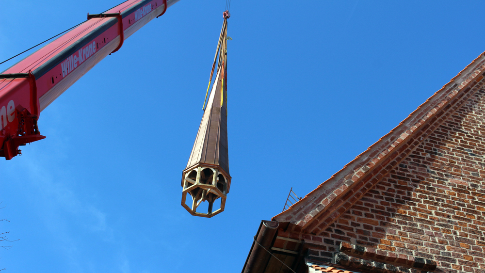Der Kirchturm am Haken des Krans