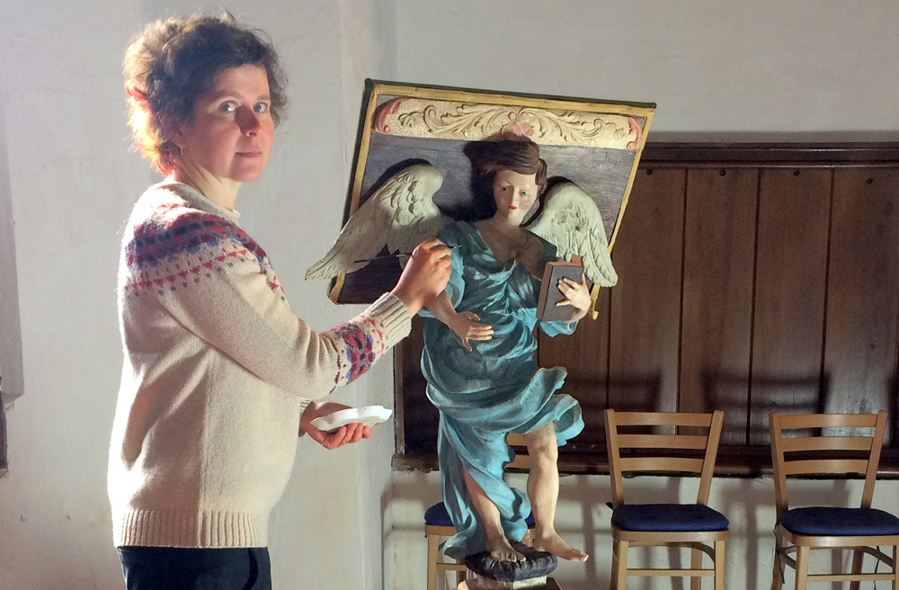 Restauratorin Jenny Heymel mit dem barocken Pult-Engel