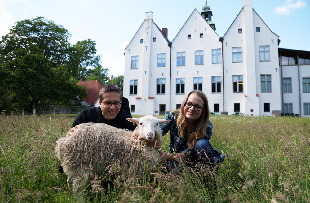 Bruder Elija Pott, Schaf Rapunzel und FÖJ-lerin Birga Müller-Stosch vor den Kloster Nütschau