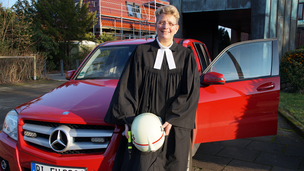 Pastorin Britta Stender mit Helm und Talar