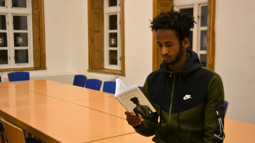 Merhawi Fsehaye aus Eritrea mit dem Buch über seine Flucht