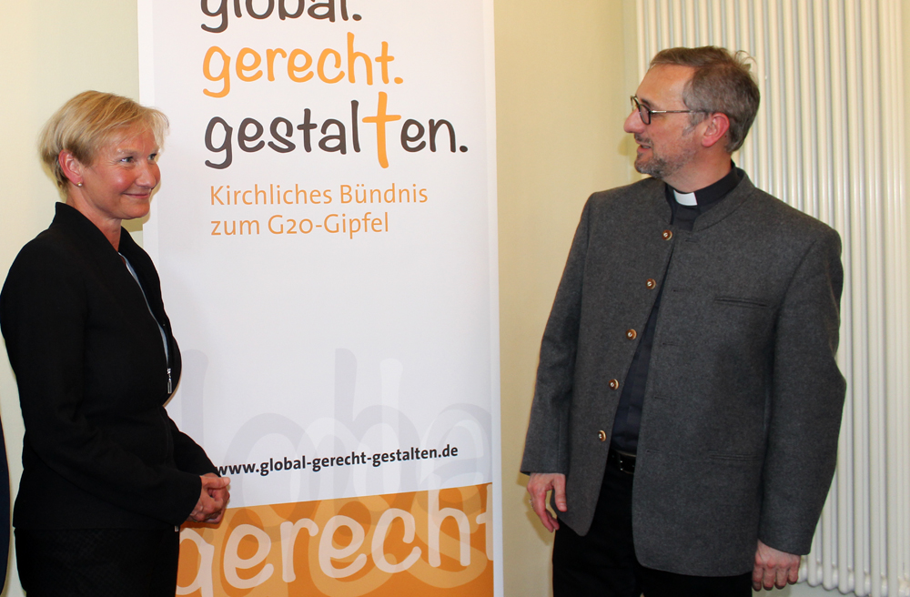 Bischöfin Kirsten Fehrs und Bischof Stefan Heße vor dem Plakat des kirchlichen Bündnisses