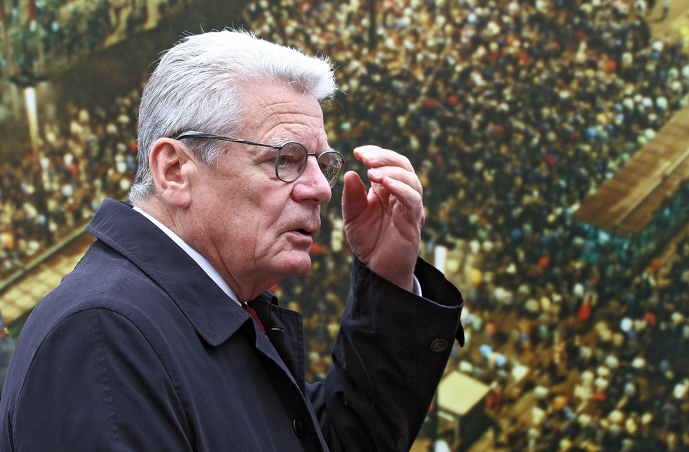Joachim Gauck vor einem Foto der Massendemonstration vom 9. Oktober 1989 in Leipzig
