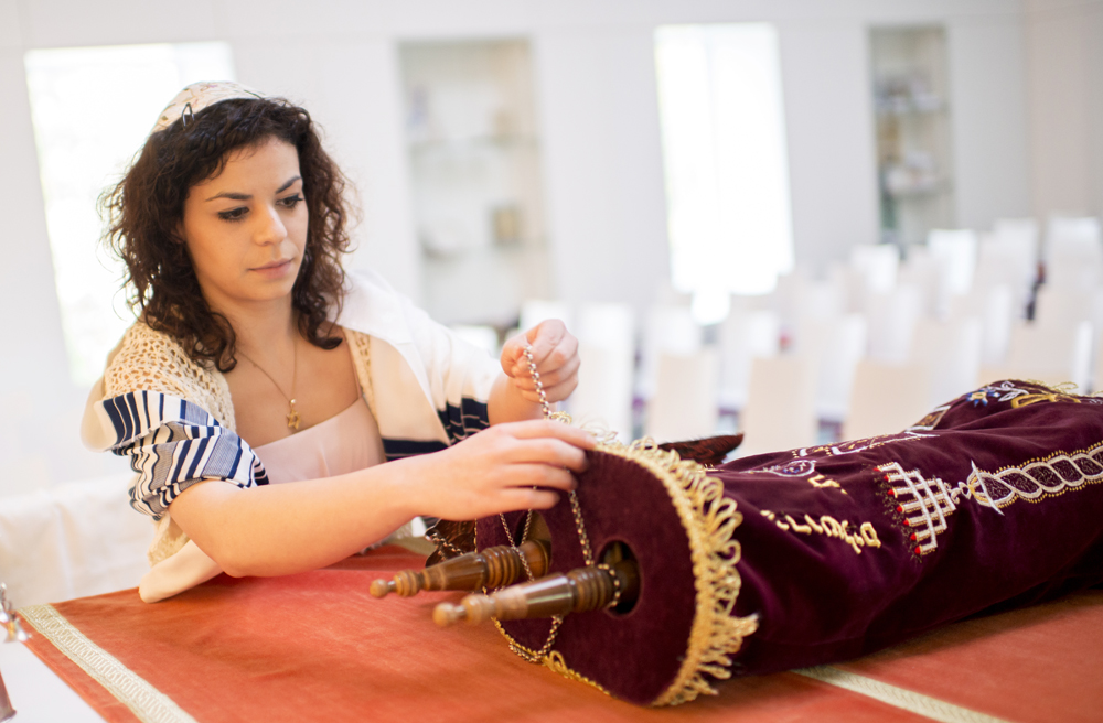 Ein Gesicht der Religionen: Judit Marach entrollt die Tora in einer Synagoge in Hannover