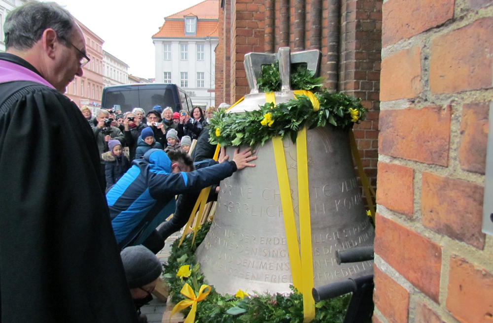 Bei der Friedensglocke müssen Zuschauer helfen, sie in die Kirche zu schieben