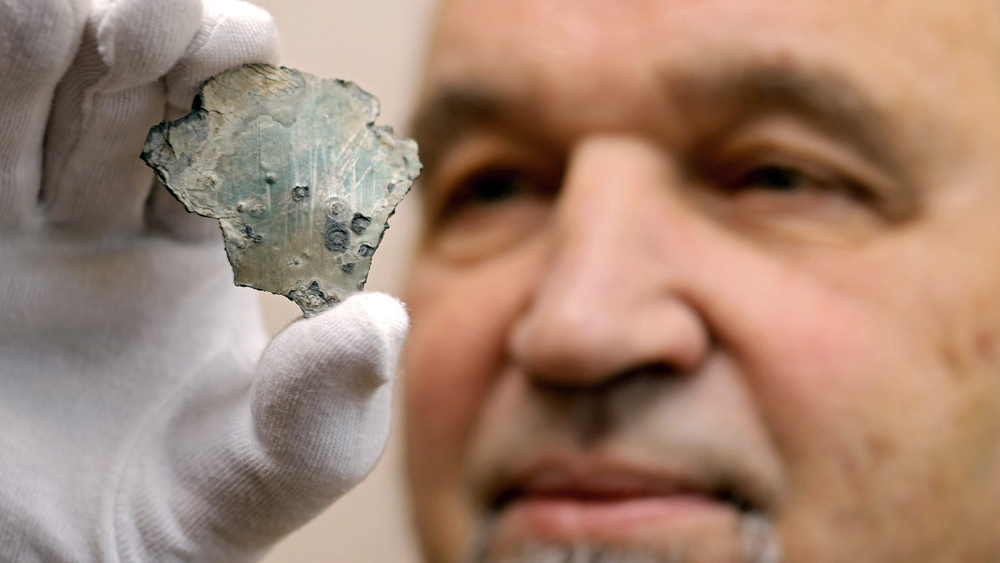 Helmut Liersch präsentiert ein Zinkstück aus Luthers Grab