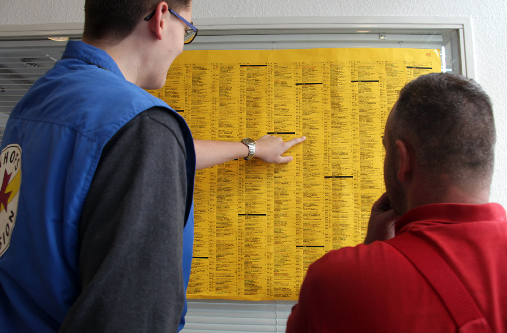 Jonas Engelking von der Bahnhofsmission hilft einem Passanten, seinen Zug zu finden