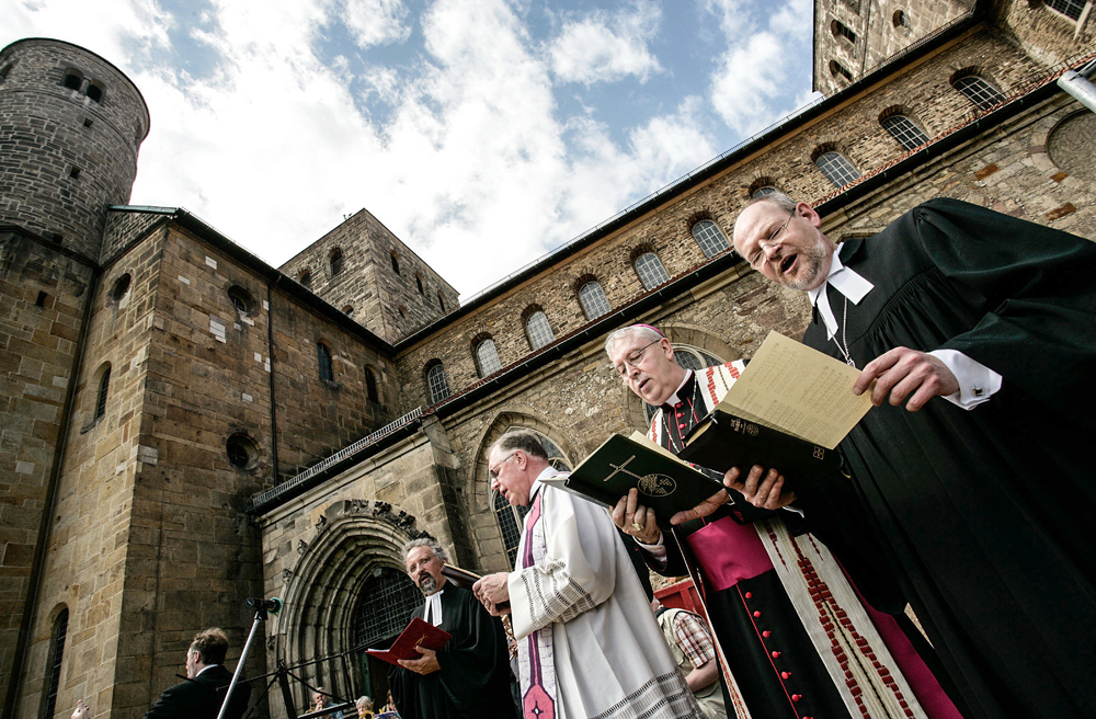 Protestanten und Katholiken singen gemeinsam vor der St. Michaeliskirche in Hildesheim