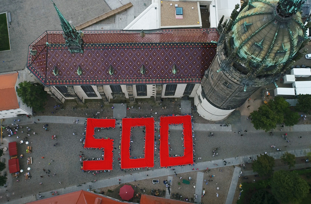 Ein von Menschen gehaltene rote "500" vor der Schlosskirche in Wittenberg weist auf das 500. Reformationsjubiläum hin.
