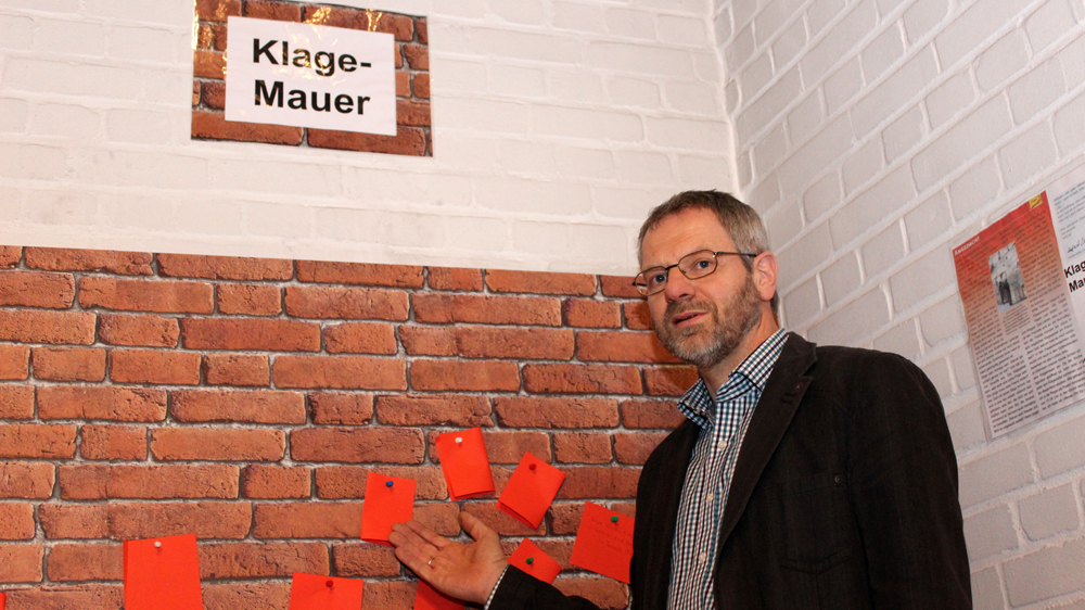Pastor Hartmut Sölter vor der Klagemauer im Altarraum der Bugenhagengemeinde