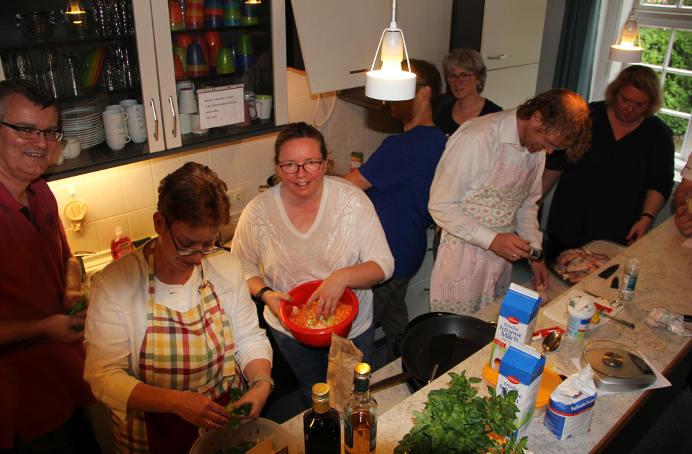 Pastorin Uta Brahms (re.) kocht mit ihrer Gruppe im Gemeindehaus
