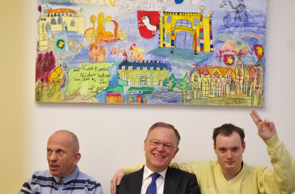 Stephan Weil, niedersächsischer Ministerpräsident, freut sich über das Kunstwerk, das HaJo Teske (l.) und Patrick Premke überreichten. 