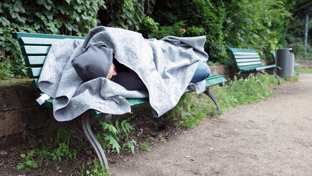 Ein Obdachloser auf einer Bank (Archivbild)