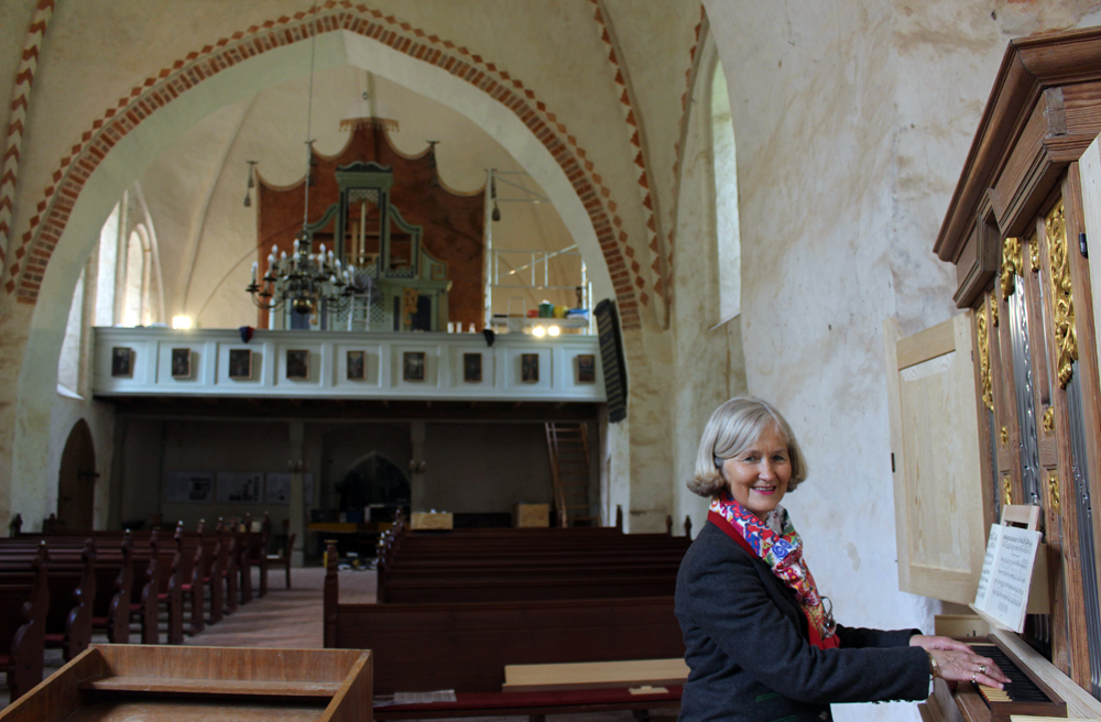 Die Vorsitzende des Fördervereins Stefanie von Laer am Richborn-Positiv im Altarraum der Dorfkirche Ruchow, im Hintergrund auf der Empore die fast fertiggestellte Paul-Schmidt-Orgel.