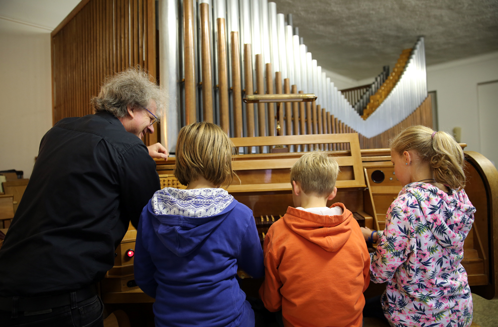 Kirchenmusiker Hans-Christoph Ebert erklärt Kindern die Orgel