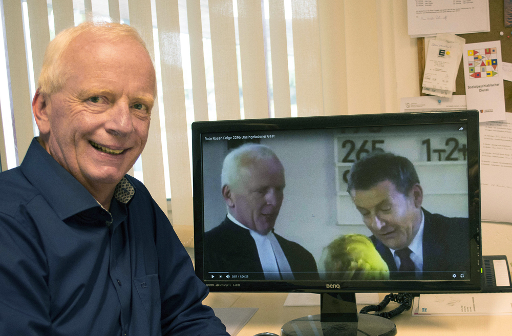 Pastor Hartmut Merten zeigt auf eine Szene, in der er in der ARD-Serie "Rote Rosen" zu sehen ist