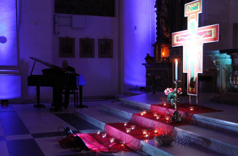 Klavier, Kerzen und Kreuz erwarten die Besucher