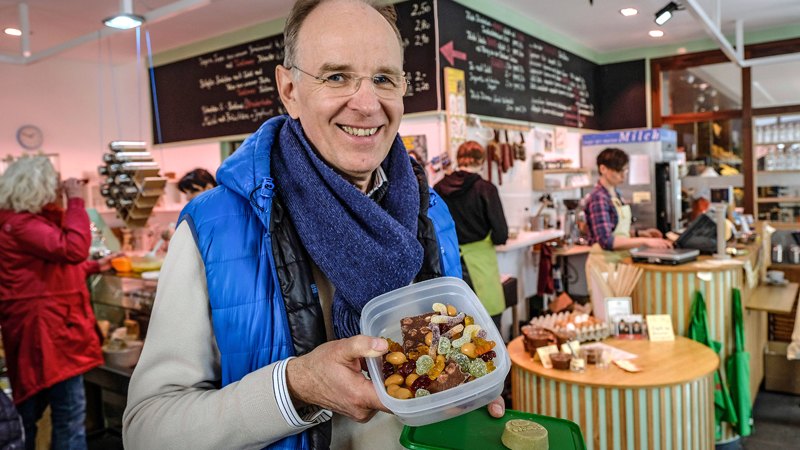 Landesbischof Meister kauft Süßigkeiten in der Tupperdose