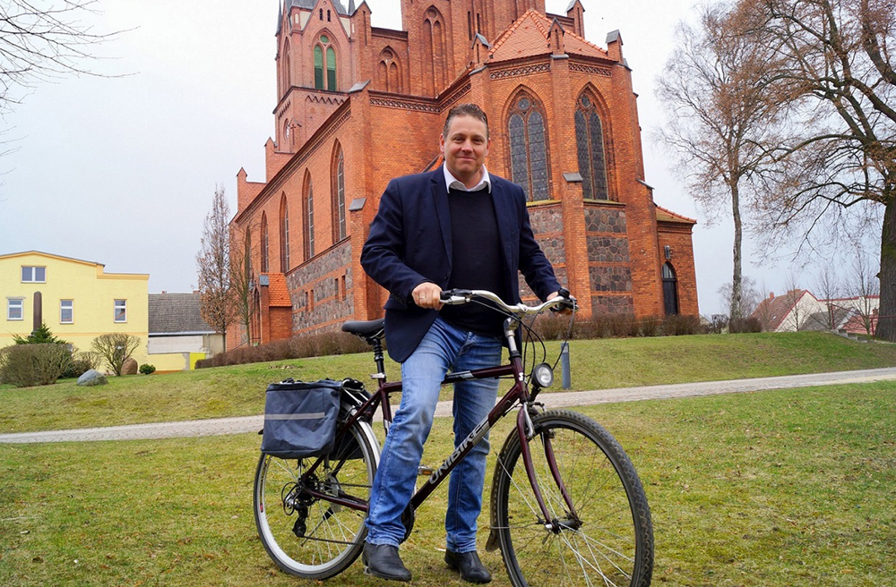 Pastor Bernhard Riedel vor der Kirche in Penkun, die zu den Stationen der deutsch-polnischen Bugenhagen-Radtour gehört