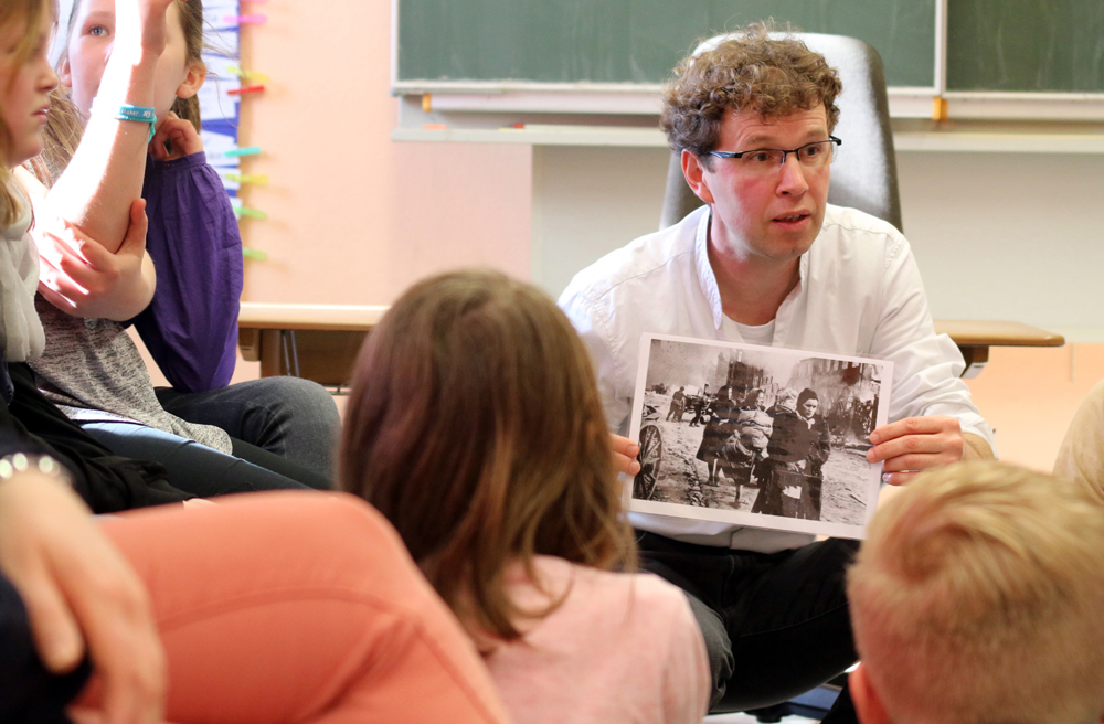 Der kirchliche Friedenspädagoge Michael Freitag-Parey diskutiert mit Grundschülern über Krieg und Frieden