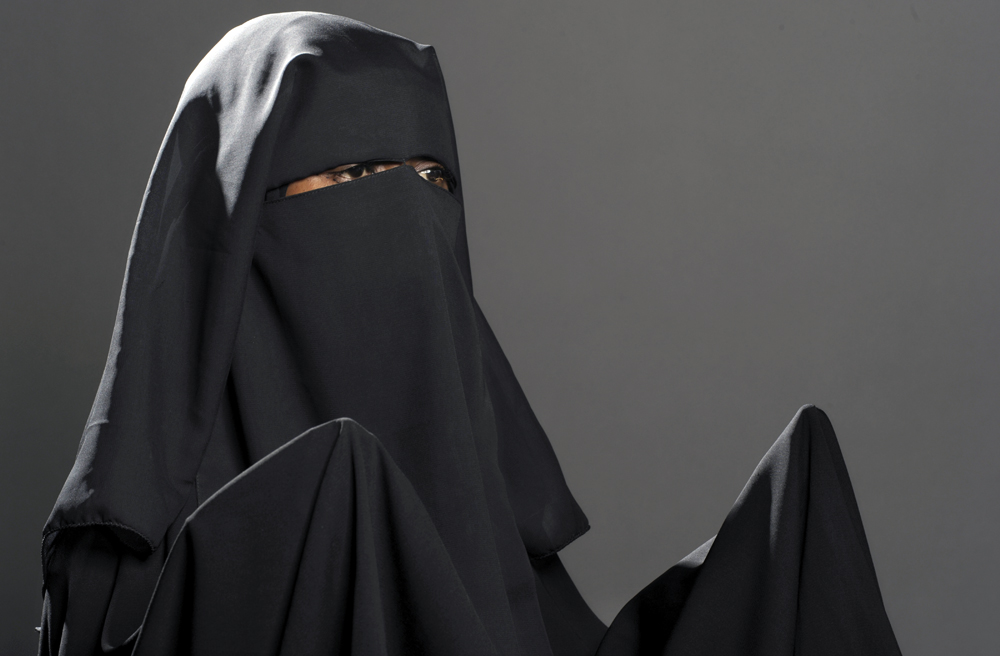 Eine Muslima im traditionellen Mantel mit passendem Khimar (Kopftuch), Unterkopftuch und Niqab, einem Gesichtsschleier (Symbolbild)