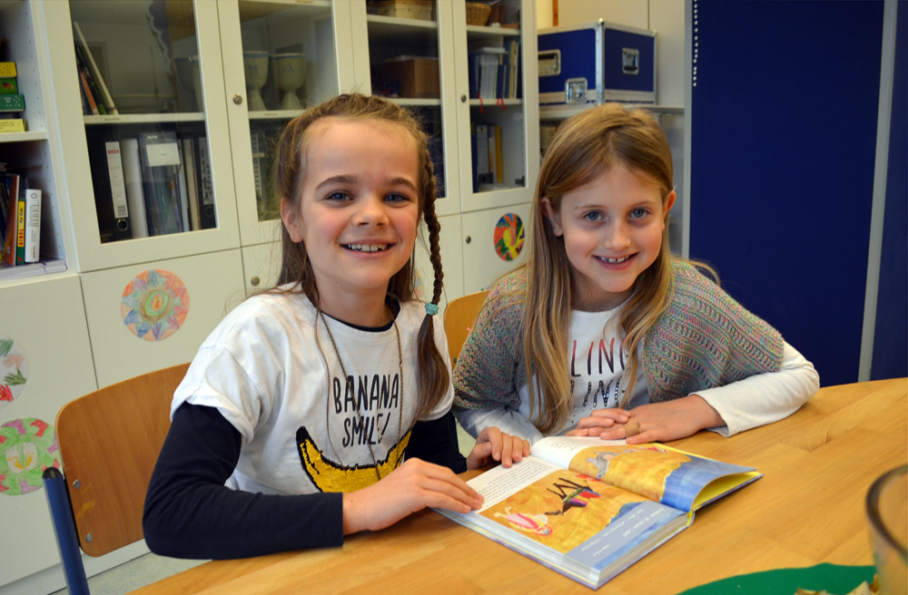 Christina (li.) und Leni studieren die Schulbibel