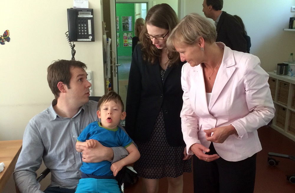 Sozialsenatorin Melanie Leonhard und Bischöfin Kirsten Fehrs im Gespräch mit Joachim Hassel, der seinen Sohn Jonas auf dem Arm trägt