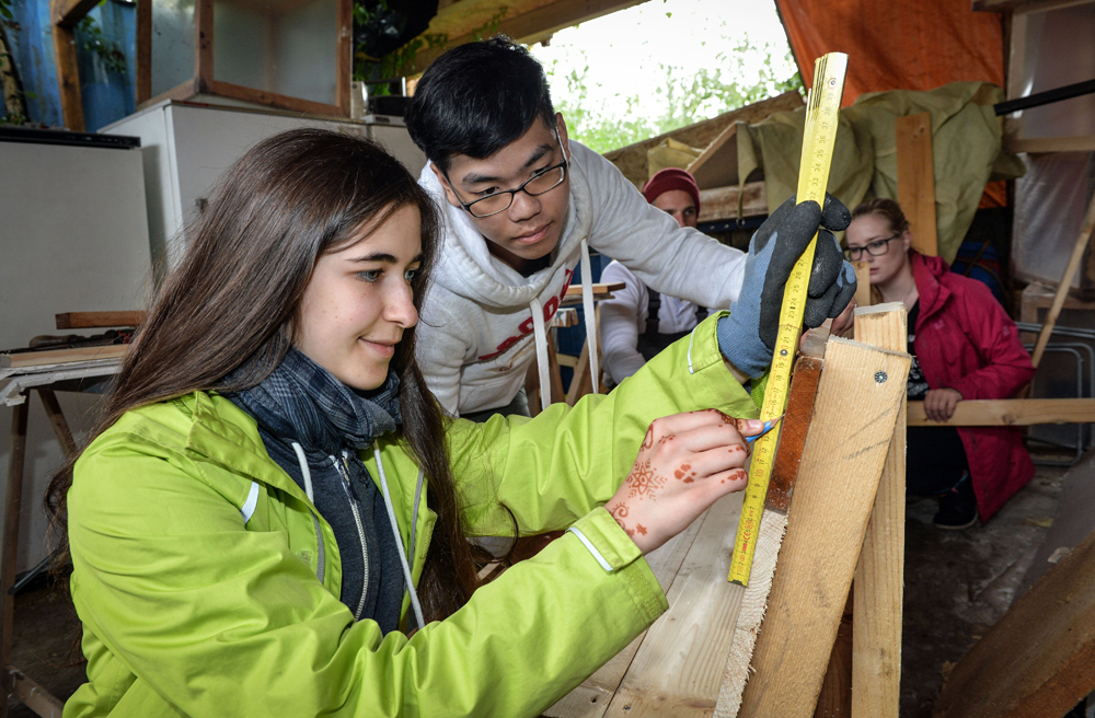 Gemeinsam bauen Mara aus Lüneburg und Alex aus Taiwan in der Holzwerkstatt eine Bank