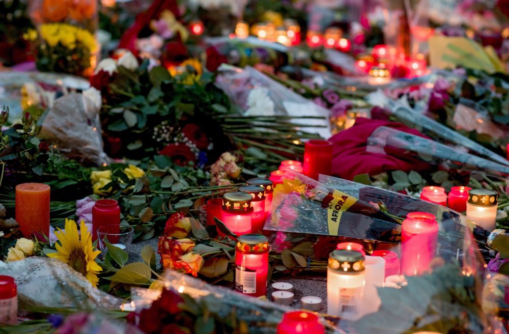 Trauernde haben in München vor dem Olympia Einkaufszentrum (OEZ) Blumen niedergelegt und Kerzen angezündet