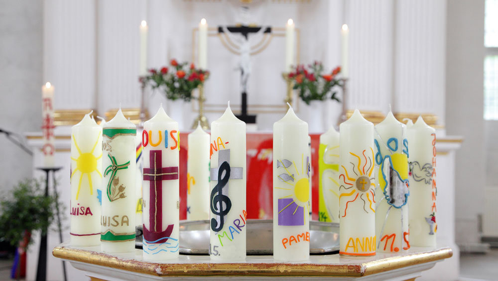 Konfirmationskerzen auf dem Taufstein, hier in der Kirche von Lohmen