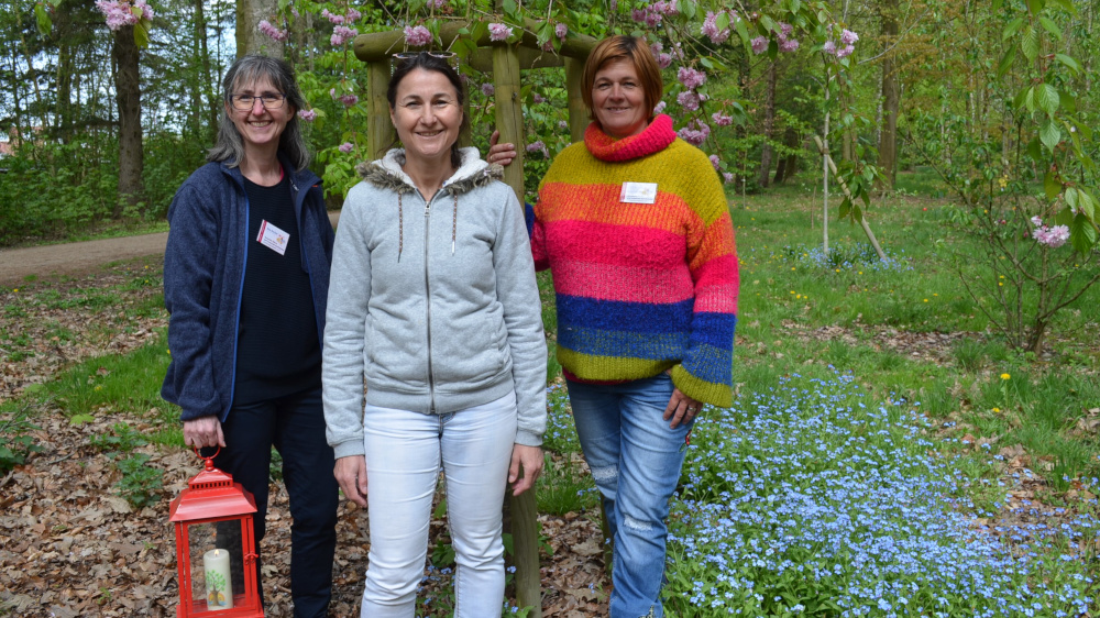 Im Rücken der Kirschbaum, mit dem 2015 die Pflanzung der „Himmelsbäume“ begann: Rita Becker, Kybele Engel und Christina Rullmann vom Verein Verwaiste Eltern und trauernde Geschwister.