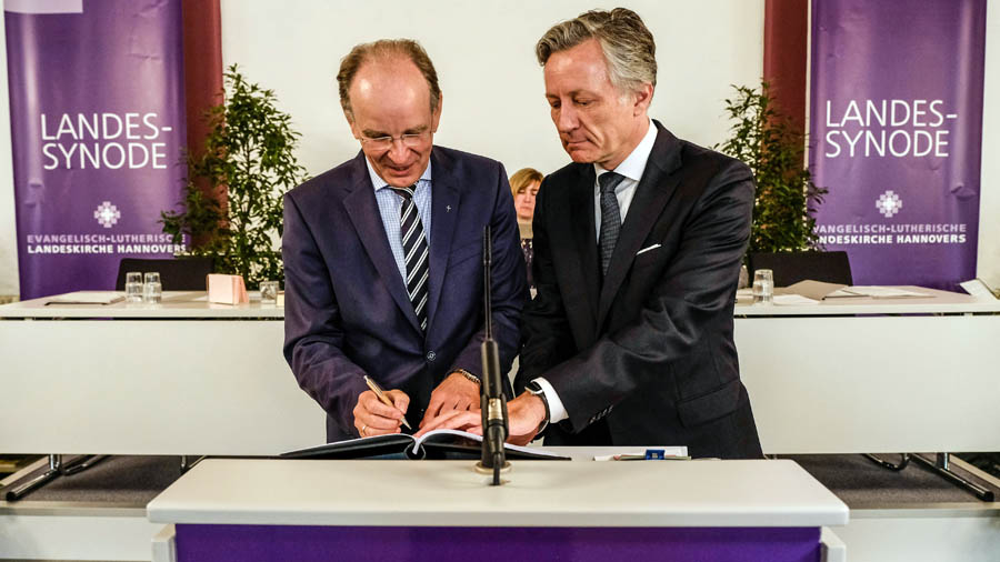Landesbischof Ralf Meister (l.) und Synoden-Präsident Matthias Kannengießer unterzeichnen die neue Verfassung