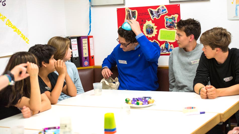 Der Jude Gerald Deutsch erläutert Kindern seine Kippa