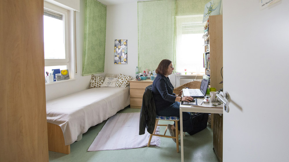 Eine Frau sitzt in einem Zimmer am Schreibtisch