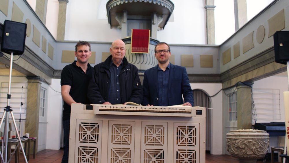 Jan Roßmanek (v.l.), Volker Reimann und Andis Paegle freuen sich über die Truhenorgel aus dem Michel.