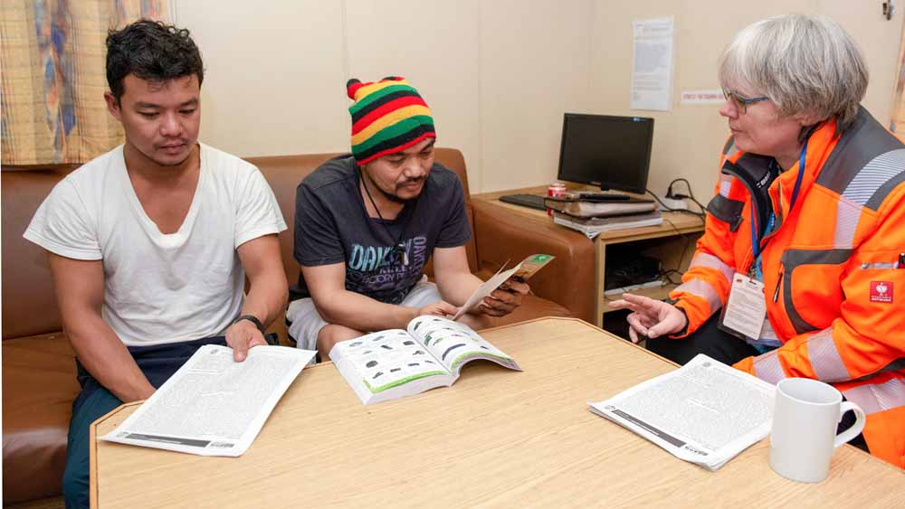 Monica Döring (r.), Leiterin der katholischen Seemannsmission Stella Maris, spricht mit Besatzungsmitgliedern