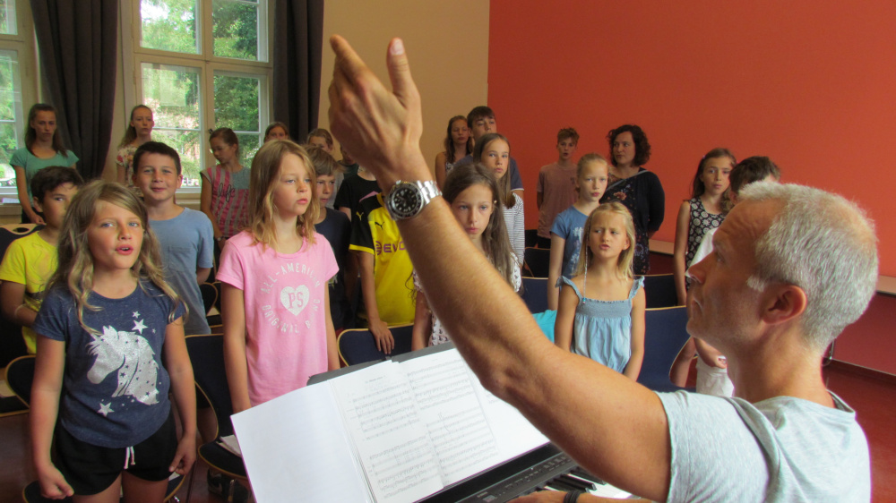 Gemeinsam einstimmen, zum Chorleiter gucken – und schwatzen geht gar nicht! Die rund 50 Kurrendekinder sind voller Aufmerksamkeit dabei.