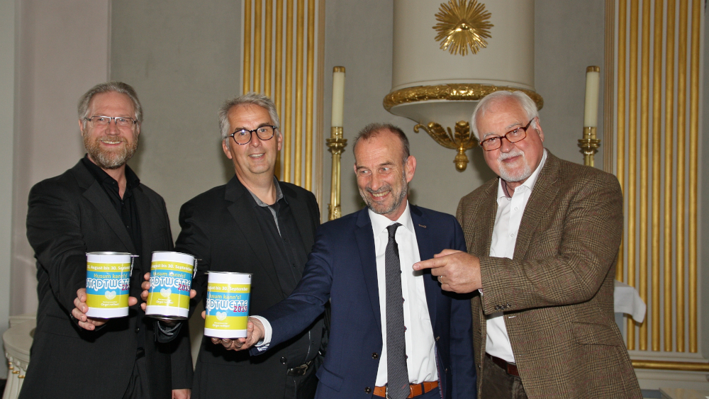 80 Spendendosen stehen in Husums Geschäften. Kai Krakenberg, Friedemann Magaard und Uwe Schmitz sowie der ehemalige Ministerpräsident Peter Harry Carstensen (v.l.) wetten, wie viel gespendet wird.