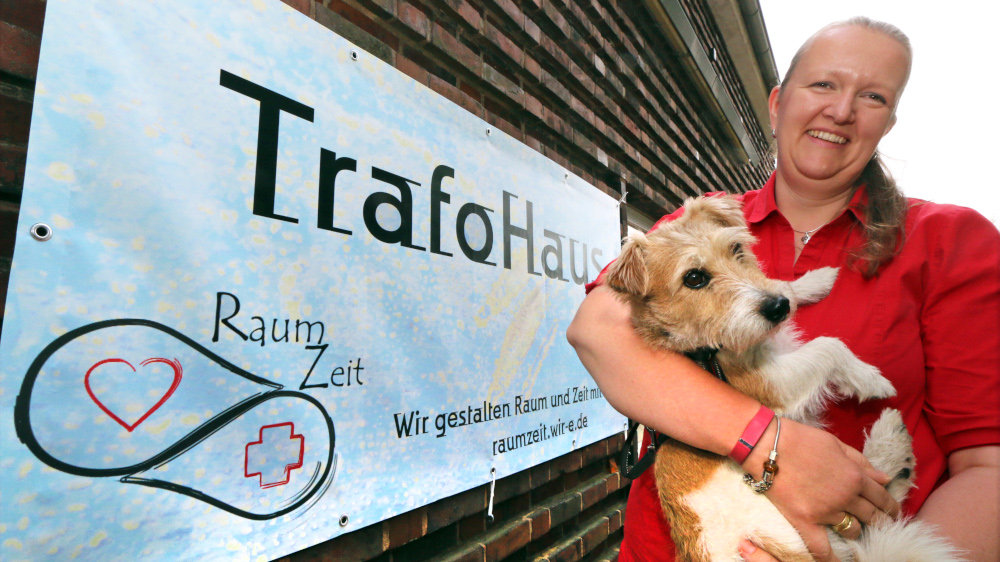 Pastorin Sabine Ulrich mit ihrem Jack-Russell-Terrier Schepsi vor dem "TrafoHaus" in Stade bei Hamburg. Die Pastorin probiert in zwei Stadtteilen von Stade "Fresh Expressions of Church" aus - neue Ausdrucksformen von Kirche.