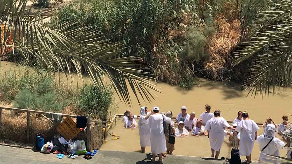 Menschen baden im Jordan – und gedenken der Taufe Jesu an diesem Ort