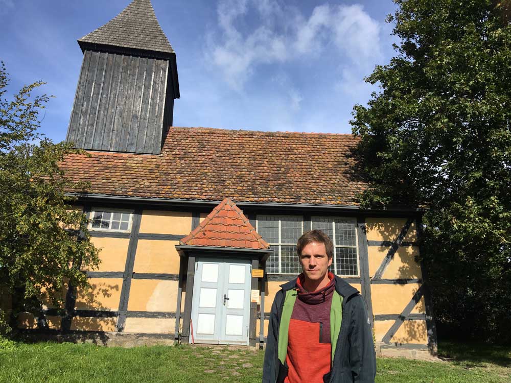 Pastor Christian Bauer vor dem schiefen Turm der Kapelle von Klempenow Foto: Sybille Marx