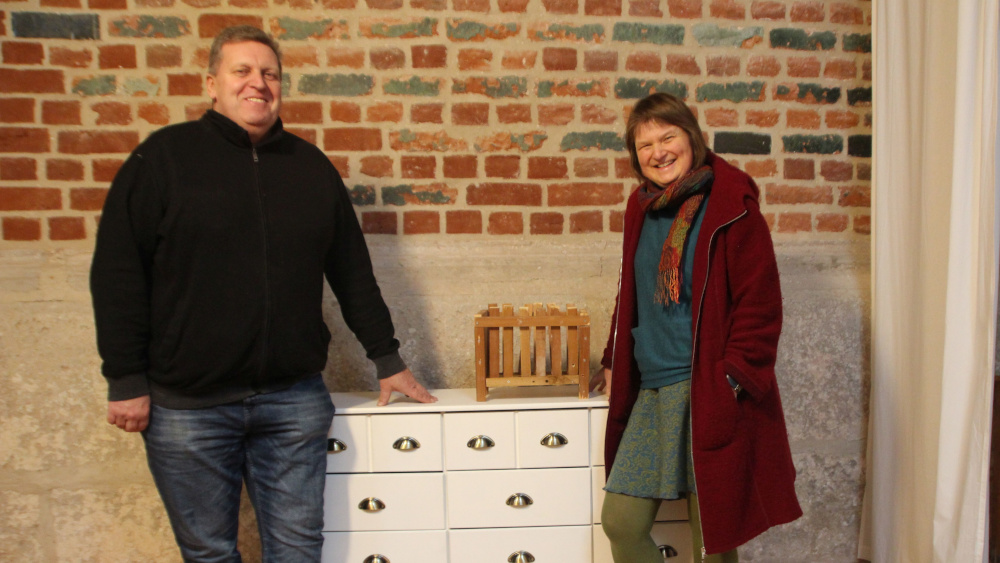Domküster Bernd Meinzer und Pastorin Beate Kempf-Beyrich an der Kommode, die als Adventskalender in der Adventskirche stehen soll.