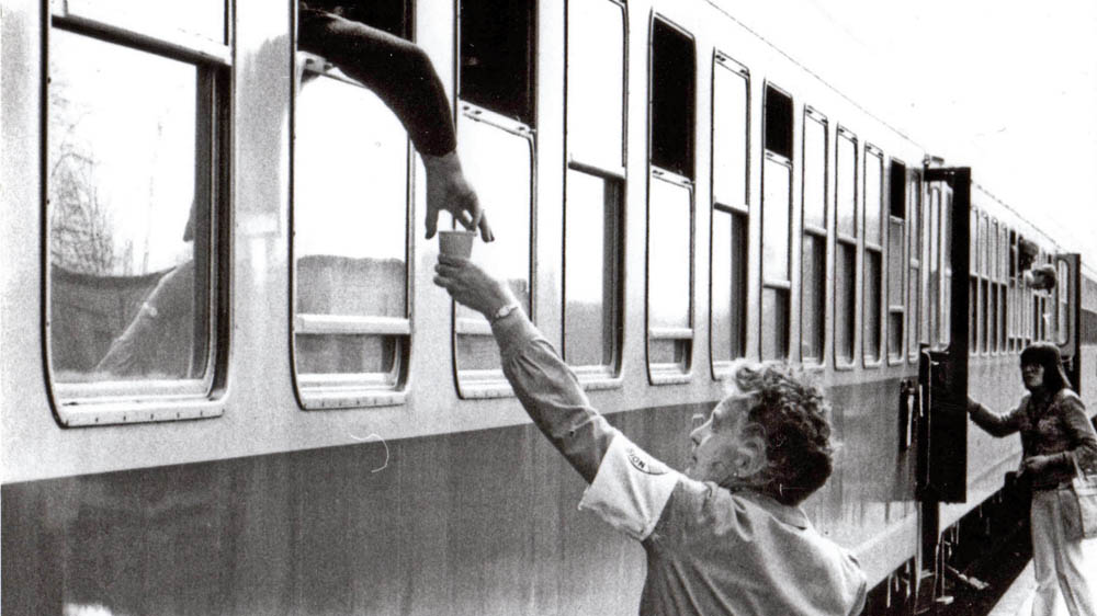 Eine Helferin verteilt Kaffee an DDR-Reisende Foto: epd