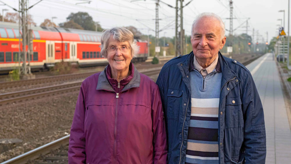 Helga Winterberg und der Pastor Jens-Peter Andresen an den Bahngleisen des Bahnhofs in Büchen