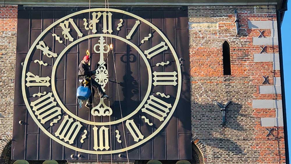 Dieser schwindelfreie Arbeiter montiert den Zeiger